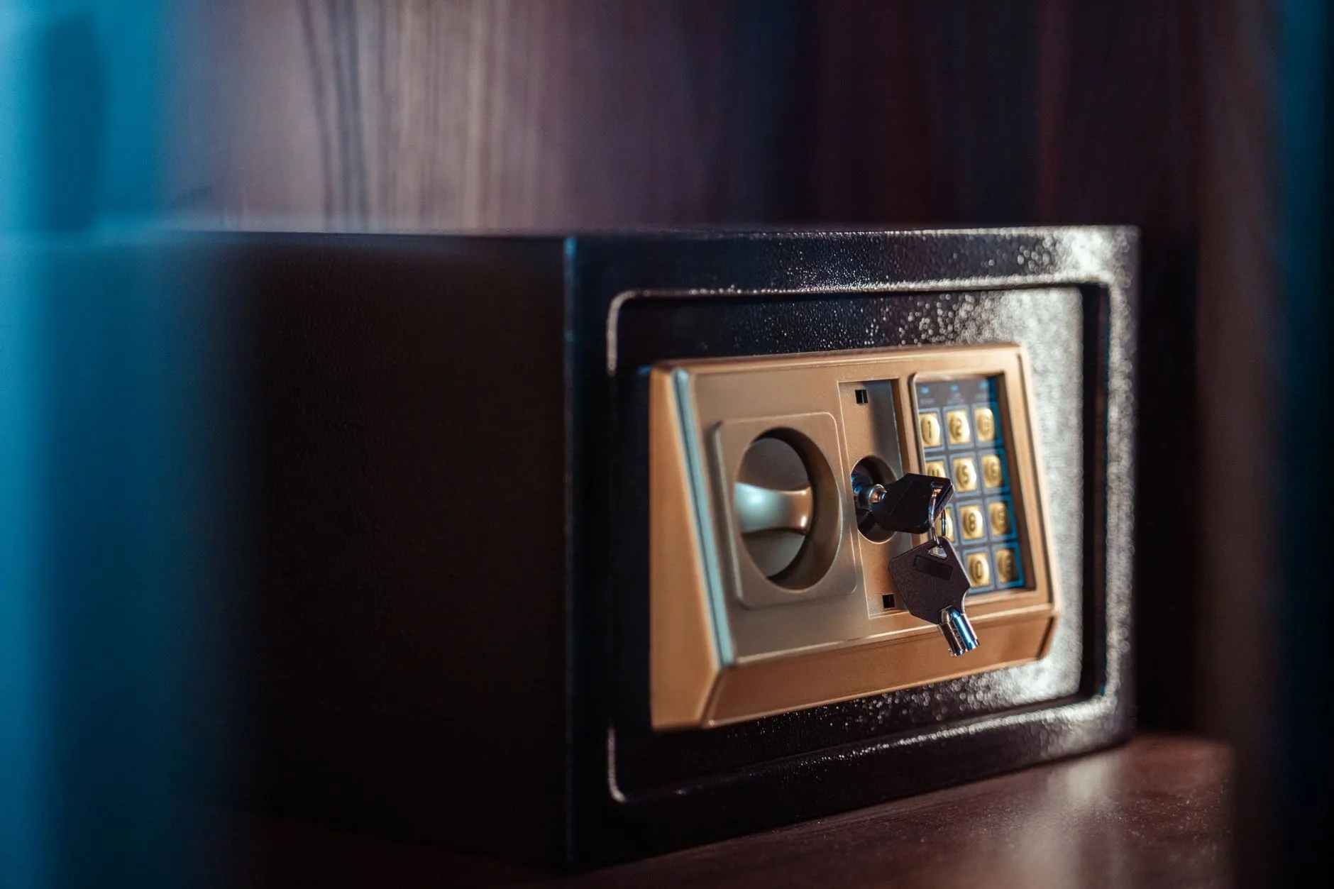A small electronic home safe with a keypad and an override key in its lock