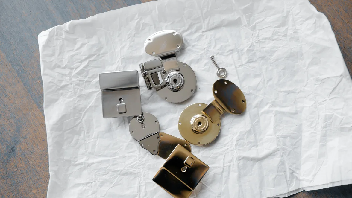 Cabinet locks and one key laid out on paper before fitting.