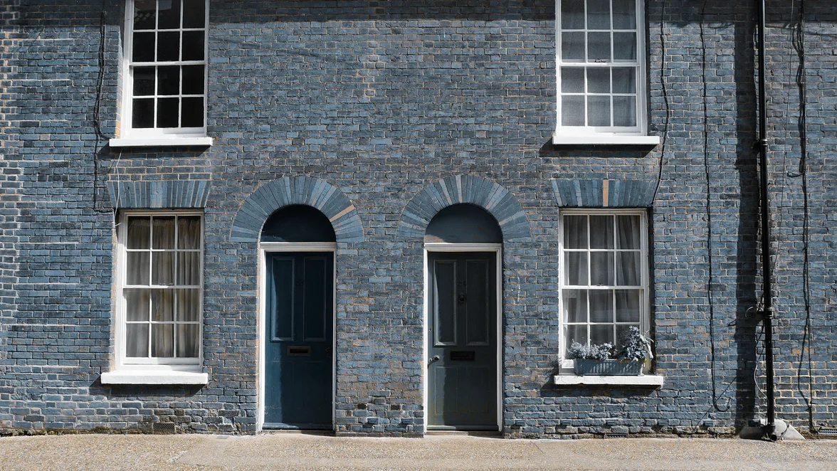 A brick terrace with its front doors on the street.
